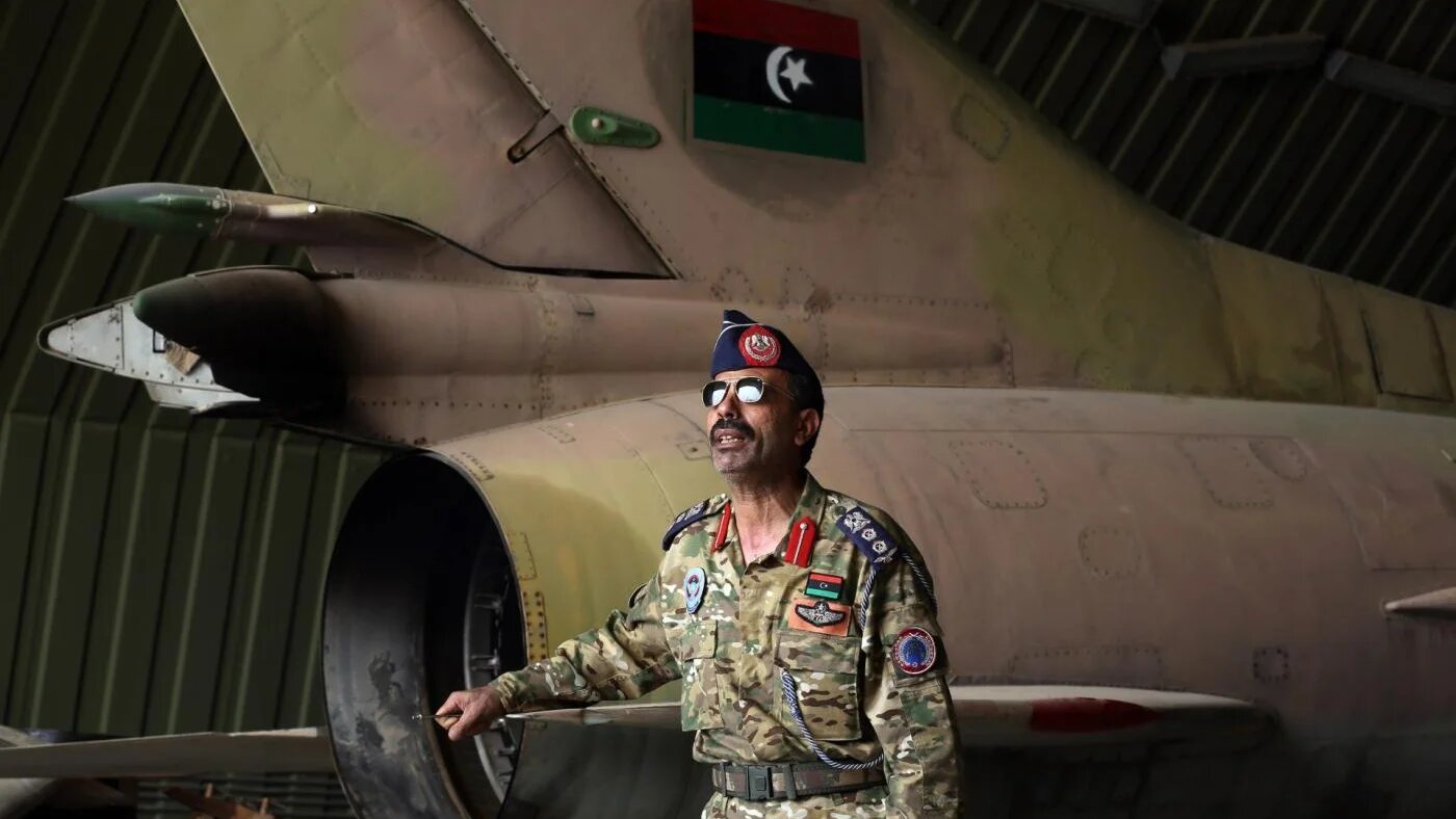 Un membre des forces armées du Gouvernement d’union nationale près d’un MiG-23 après la prise de la base aérienne d’al-Watiya en mai (AFP)