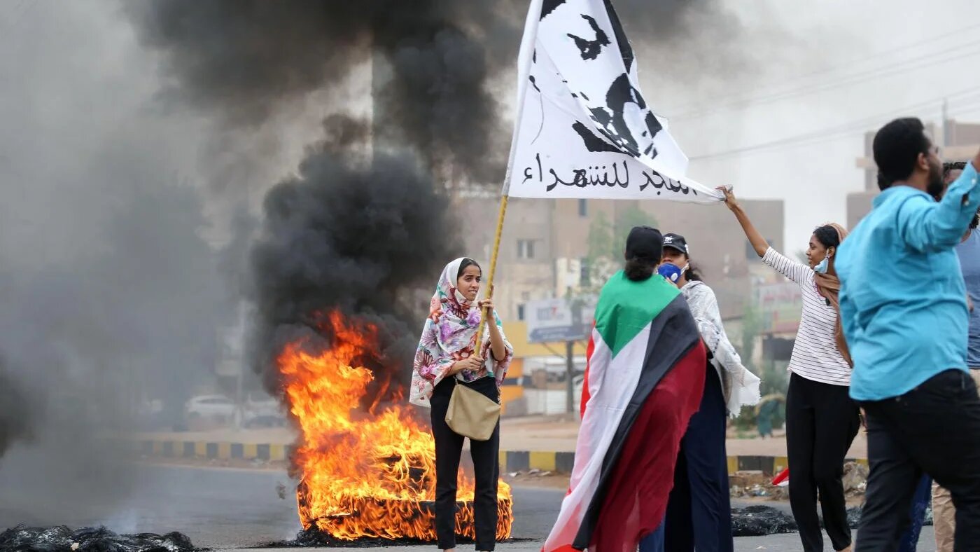 Une Soudanaise brandit un drapeau « Gloire aux martyrs » pendant une manifestation à Khartoum, le 23 mai 2020, pour commémorer le premier anniversaire du massacre du 3 juin (AFP)