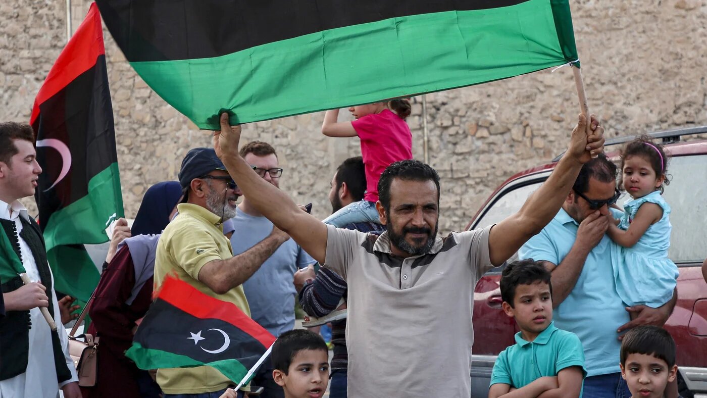 Un homme brandit un drapeau national libyen au cours de célébrations dans la capitale Tripoli, après que le Gouvernement d’union nationale (GNA) reconnu par l’ONU a déclaré avoir repris le contrôle total de la capitale le 4 juin (AFP)
