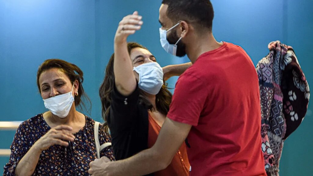 Retrouvailles entre membres d’une famille à l’aéroport Tunis-Carthage, le 27 juin 2020 (AFP)