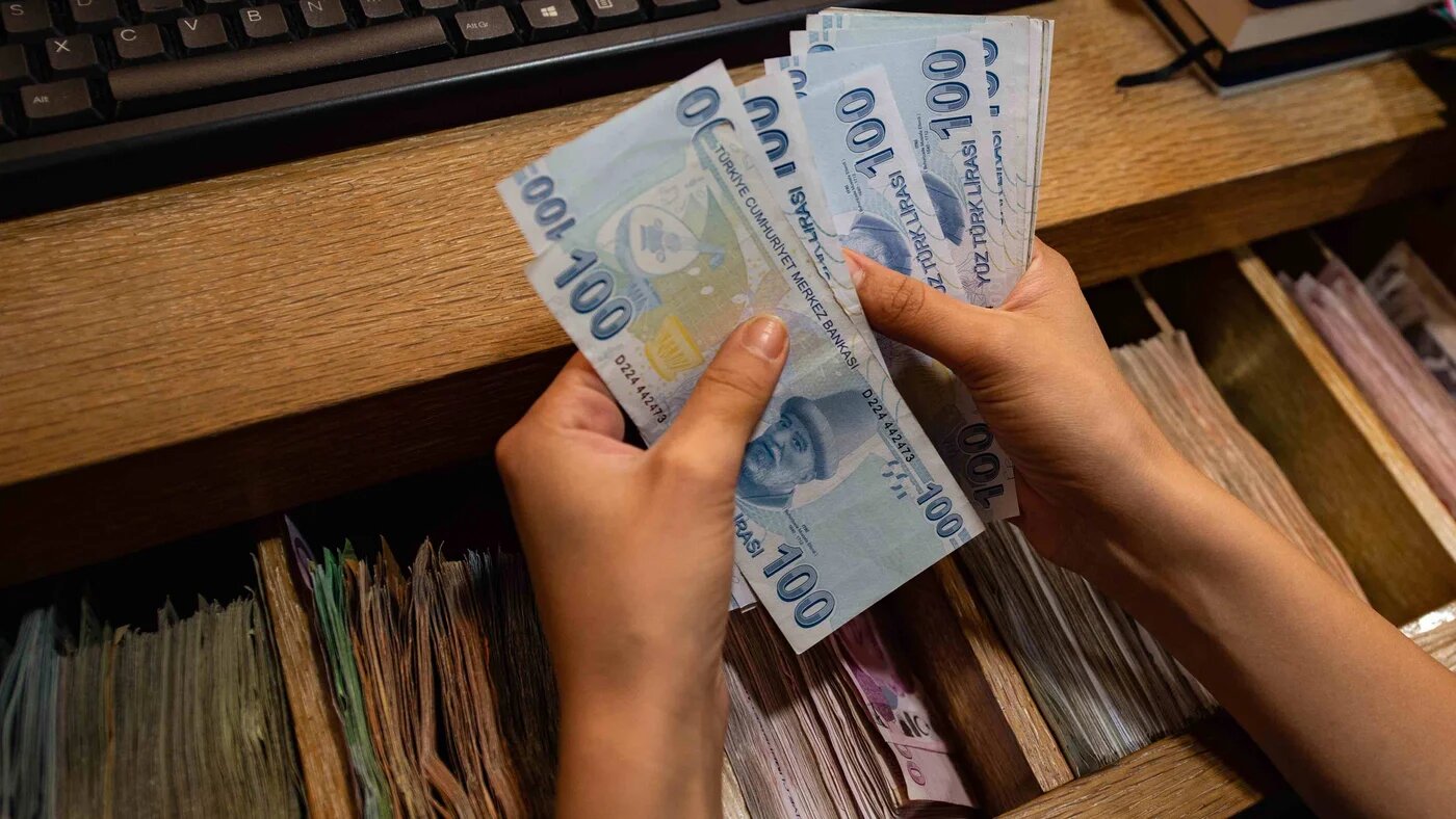 A currency exchange office worker counts Turkish Lira