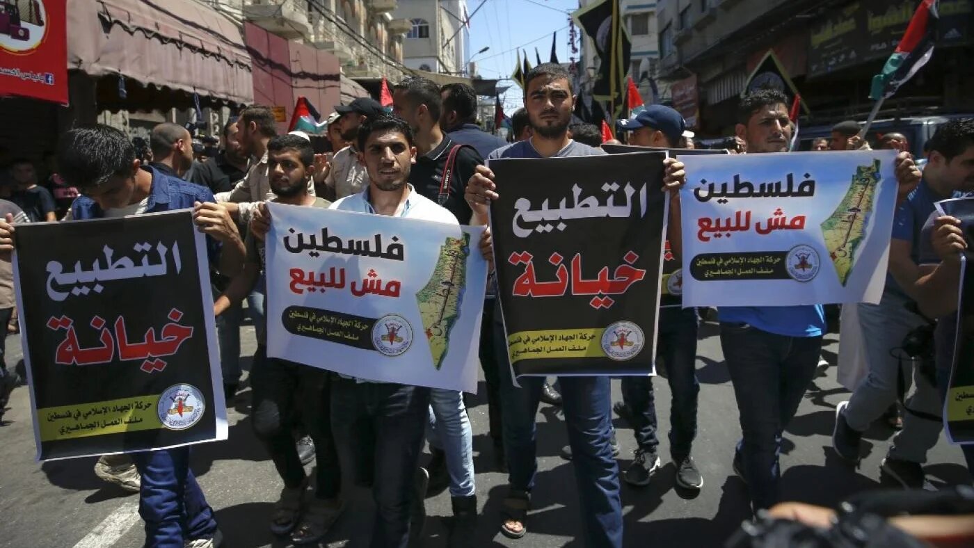 « La normalisation est une trahison » et « la Palestine n’est pas à vendre » : slogans pendant une manifestation contre l’accord entre Israël et les EAU négocié par les États-Unis dans la ville de Gaza, le 14 août (AFP)