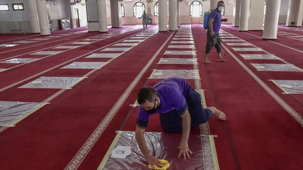 Des volontaires désinfectent la salle de prière d’une mosquée de Kouba, à Alger, le 15 août 2020 (AFP) 