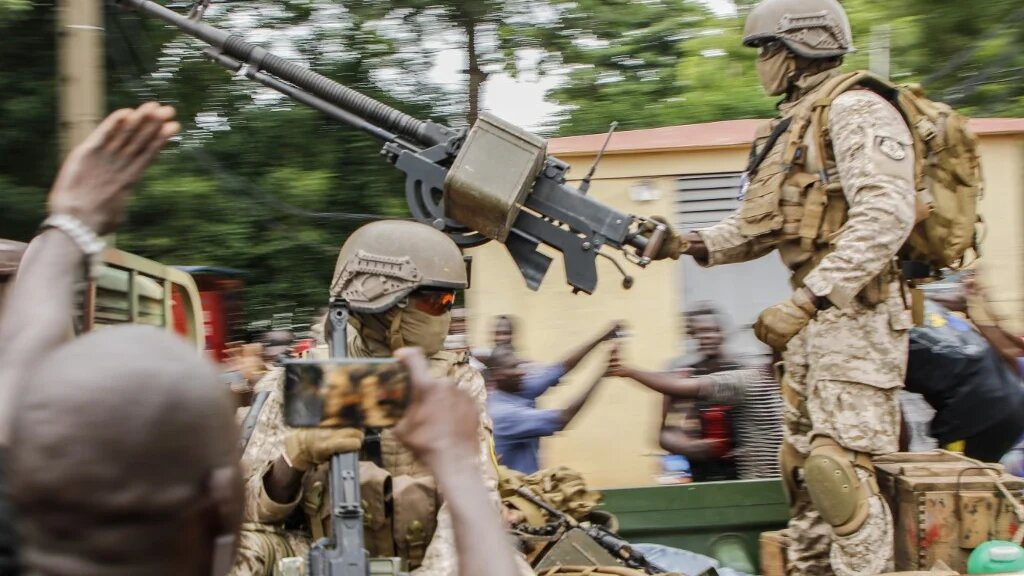 Des soldats maliens défilent à leur arrivée en véhicule militaire sur la place de l’indépendance à Bamako, le 18 août 2020, après l’arrestation du président malien Ibrahim Boubacar Keïta (AFP)
