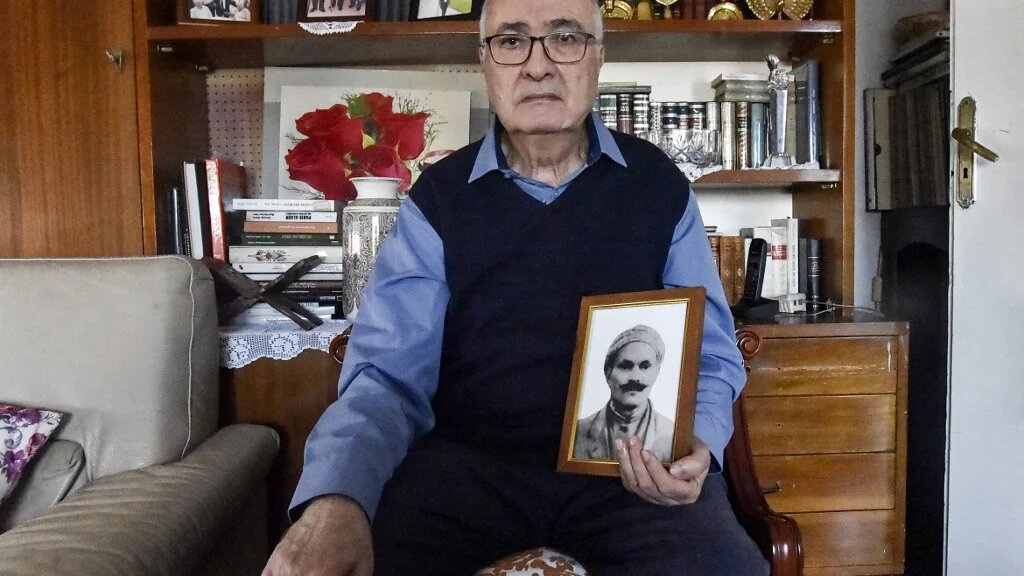 Mohamed Tazir pose, à Alger, le 20 février 2022, avec la photo de son grand-père, disparu en 1957 après son arrestation par l’armée française (AFP/Ryad Kramdi)