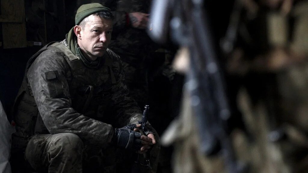 Un militaire des forces ukrainiennes attend un bombardement dans un abri sur une position dans la région de Louhansk le 5 mars 2022 (AFP/Anatolii Stepanov)