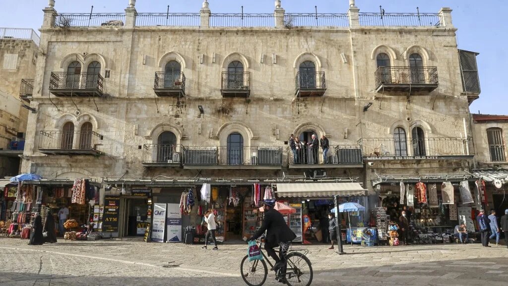 Un homme passe devant l’hôtel Petra, porte de Jaffa, dans la vieille ville de Jérusalem alors que les chefs religieux chrétiens se rencontrent à l’intérieur (AFP/Hazem Bader)