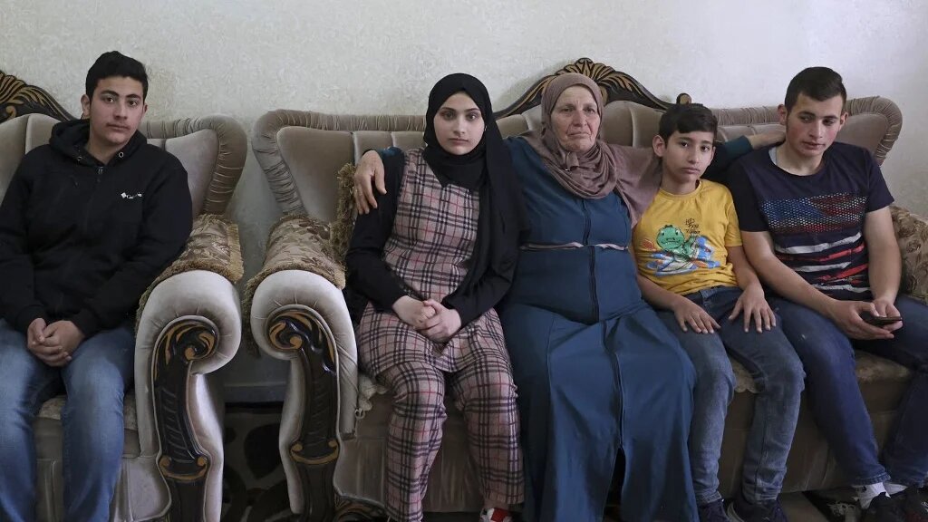 Houria Sabateen, dont la fille a été abattue par un soldat israélien le 10 avril, auprès de ses petits-enfants près de Bethléem en Cisjordanie occupée (AFP/Hazem Bader) 