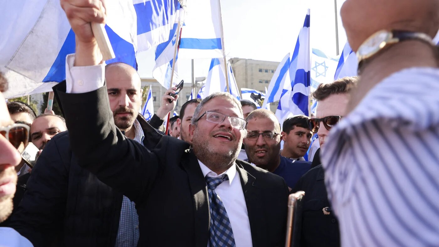 Israeli far-right lawmaker and leader of the Jewish Power party Itamar Ben-Gvir, raises an Israeli flag in Safra square in Jerusalem on 20 April 2022 (AFP)
