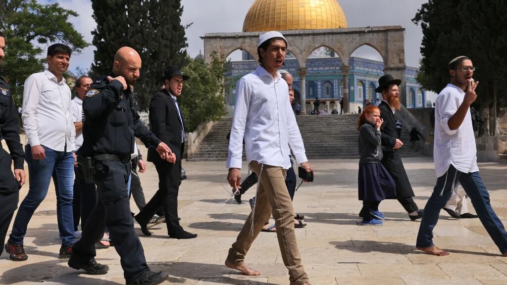 Israeli police accompany a group of Israeli far-right activists during a storming of al-Aqsa Mosque in the Old City of Jerusalem on 5 May 2022. (AFP)