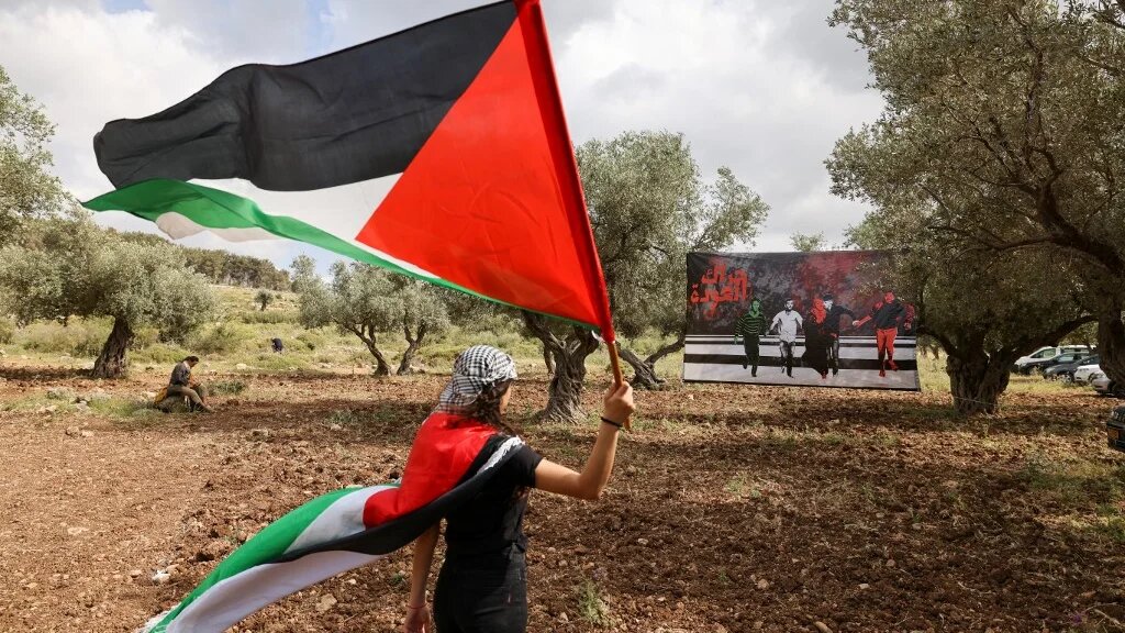 A protestor waves a Palestinian national flag during a demonstration near the city of Sakhnin in northern Israel, on 5 May 2022 (AFP)