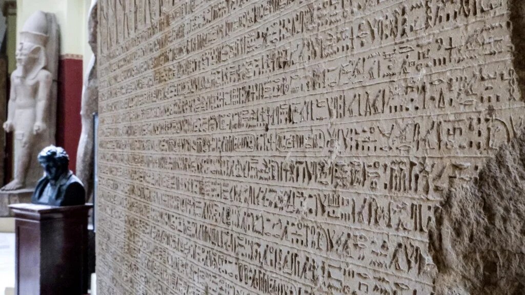 Un buste de Jean-François Champollion au Musée égyptien de la capitale égyptienne, avec à ses côtés le décret de Canope, inscrit sur une stèle. Ayant un plus grand nombre de hiéroglyphes différents que la pierre de Rosette, cette stèle s’est avérée cruciale pour déchiffrer l’écriture (AFP/Amir Makkar)