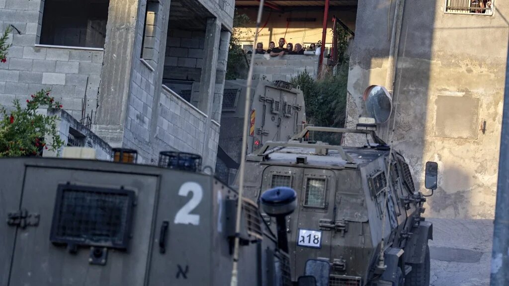 Israeli army's vehicles drive during a raid on a house in the town of Rummanah, near the flashpoint town of Jenin in the occupied West Bank on 8 May 2022. (AFP) 