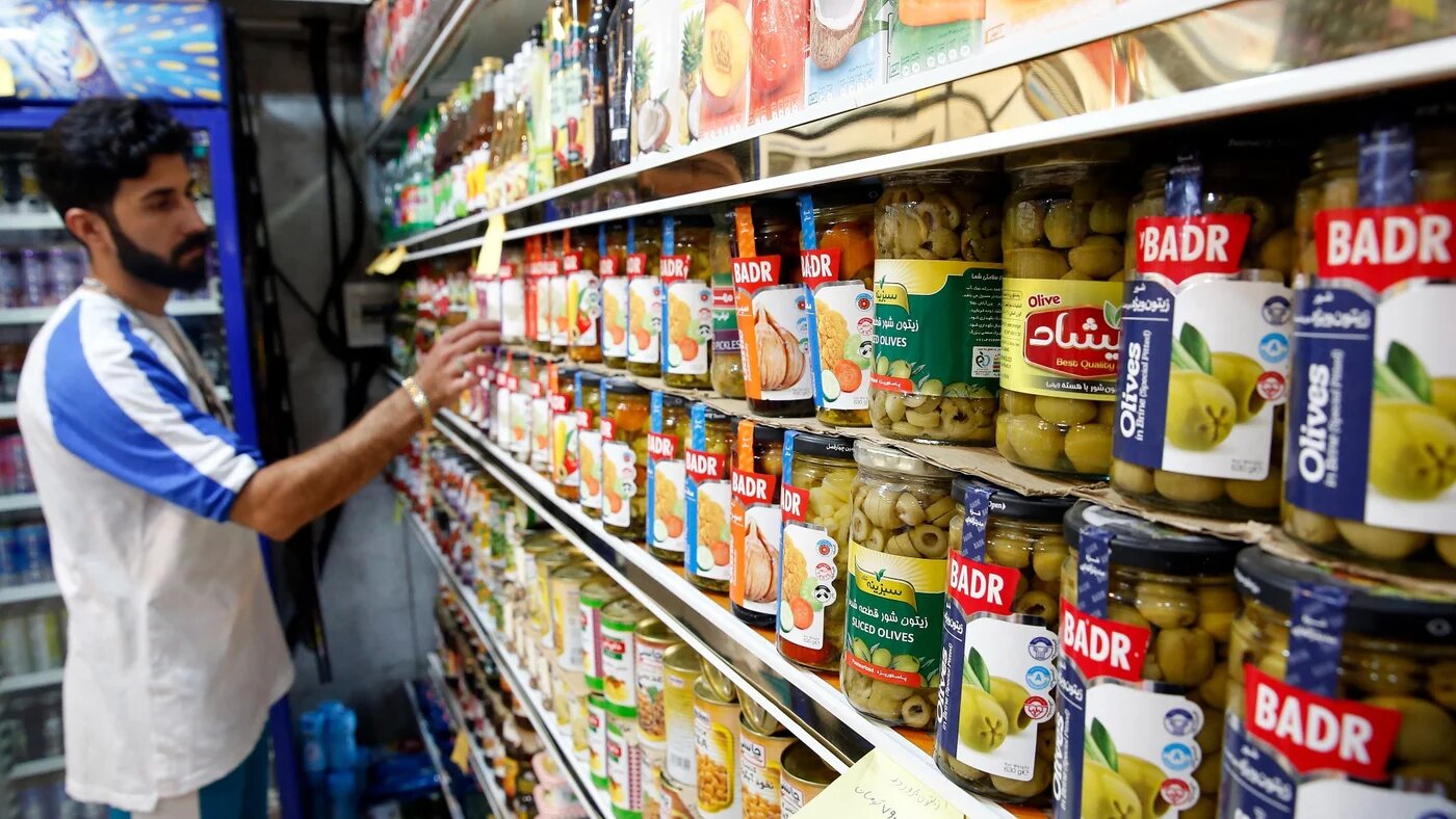 An Iranian shops at a food store in the capital Tehran as prices on basic goods soar (AFP)