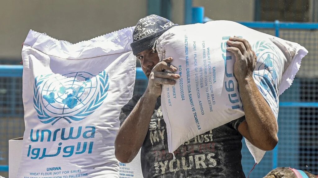 Palestinians receive their monthly food rations from the United Nations Relief and Works Agency (Unrwa) warehouse in Khan Younis in the southern Gaza Strip on 14 June 2022 (AFP)