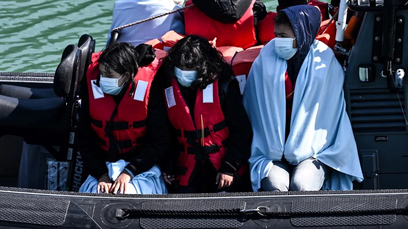 Migrants are seen on the UK Border Force rubber dinghy, after they were picked up at sea while attempting to cross the English Channel, and brought to the Marina in Dover, southeast England, on June 16, 2022 (AFP)