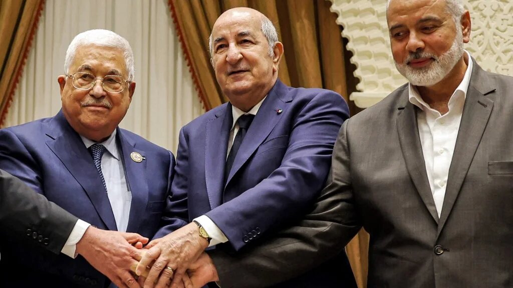 A handout picture provided by the Palestinian Authority's press office (PPO) on 5 July 2022 shows (L to R) Palestinian president Mahmud Abbas shaking hands with Algerian President Abdelmajid Tebboune and with Palestinian Hamas movement's leader Ismail Haniyeh. (AFP) 