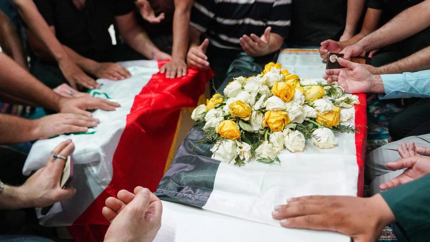 Iraqi mourners pray over the caskets of a woman and her niece killed in Zakho during their funeral in Najaf on 21 July 2022 (AFP)