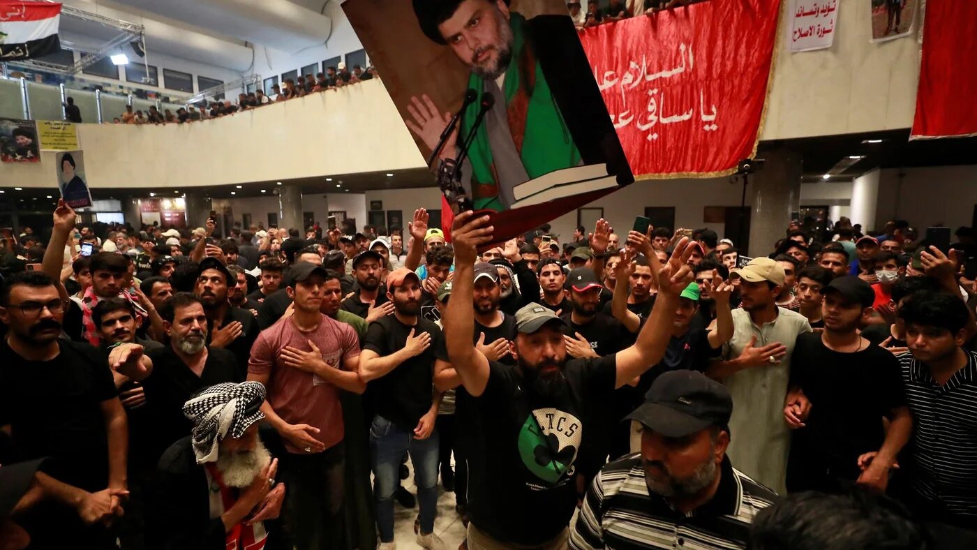 Supporters of Iraqi cleric Moqtada Sadr (portrait), protesting against a rival political bloc's nomination for prime minister, occupy Iraq's parliament in the capital Baghdad's high-security Green Zone, on August 1, 2022 (AFP)
