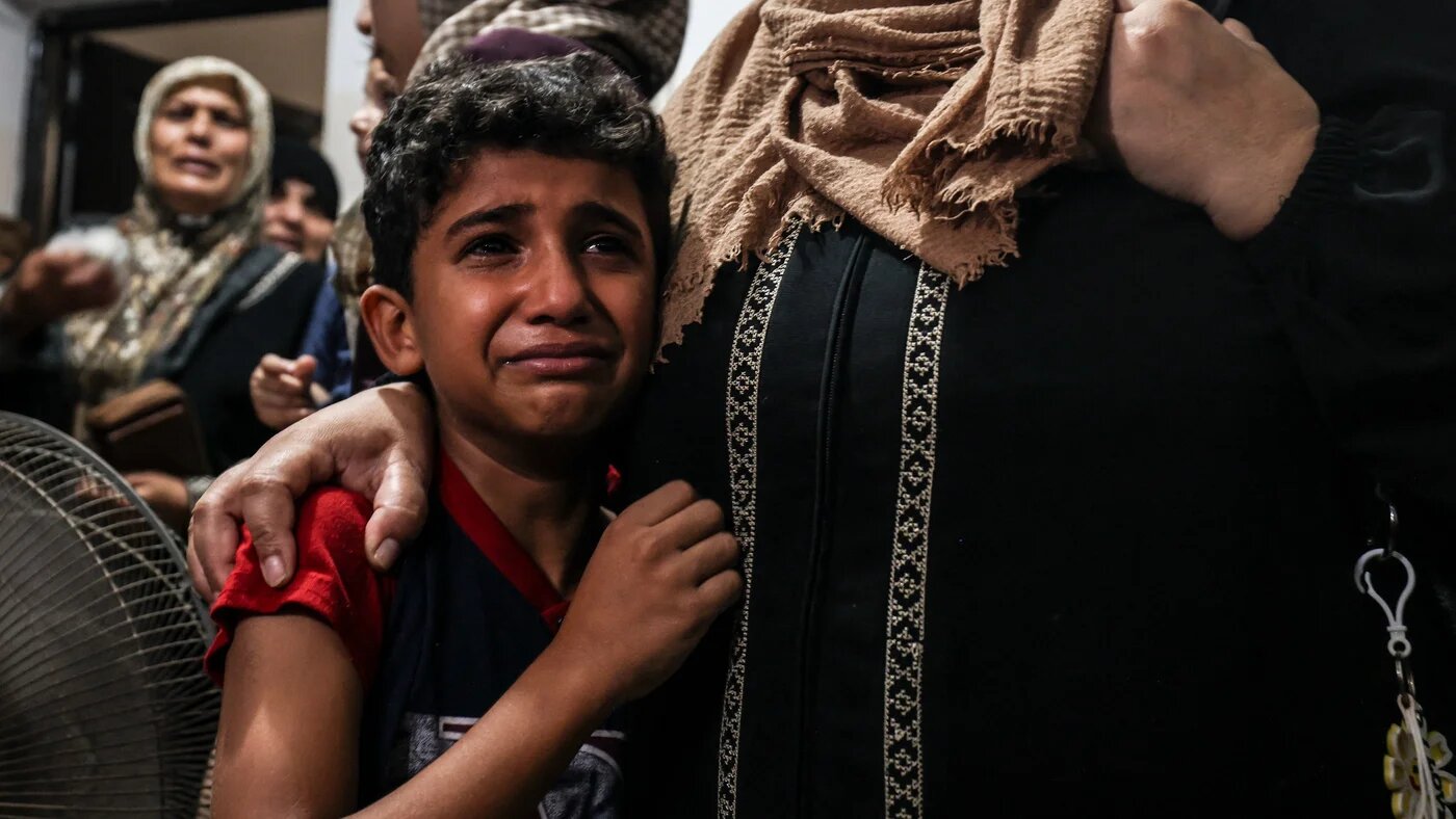 Relatives of a young Palestinian killed during the night in the Jabalia refugee camp in the northern Gaza Strip, react during his funeral in the same camp, on 7 August 2022. (AFP)