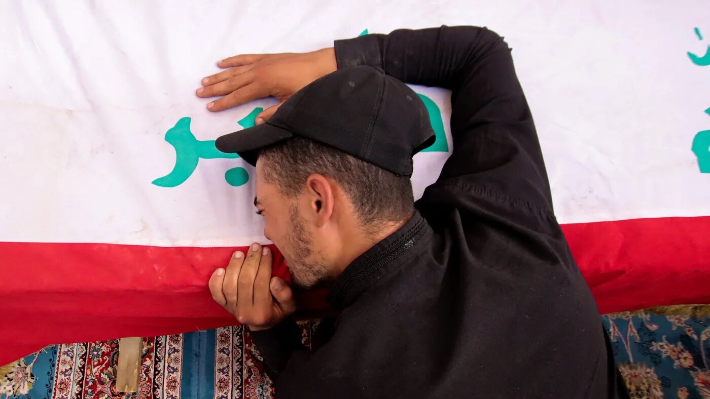 A mourner attends a mass funeral for supporters of Muqtada al-Sadr who were killed during clashes in Baghdad's Green Zone, at a cemetery in Najaf on 30 August (AFP)
