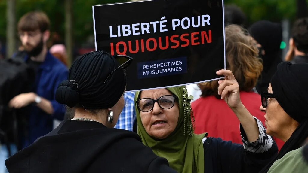 Une manifestante brandit une pancarte lors d’un rassemblement de soutien à l’imam Hassan Iquioussen, place de la République à Paris le 3 septembre 2022 (AFP/Jean-Christophe Verhaegen)