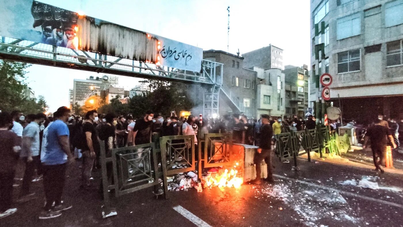 A picture obtained by AFP outside Iran on September 21, 2022, shows Iranian demonstrators burning a rubbish bin in the capital Tehran during a protest for Mahsa Amini (AFP)