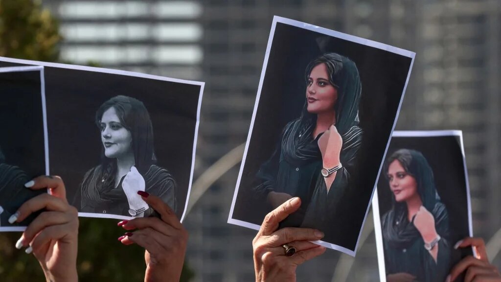 Des femmes brandissent des pancartes imprimées de la photo de Mahsa Amini, décédée à 22 ans alors qu’elle était détenue par les autorités iraniennes, lors d’une manifestation dénonçant sa mort devant les bureaux de l’ONU à Erbil, la capitale du Kurdistan autonome d’Irak, le 24 septembre 2022 (AFP/Safin Ahmed)