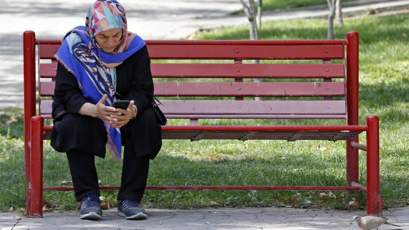 A woman sits at a park in Iran's capital Tehran, September 27, 2022 (AFP)