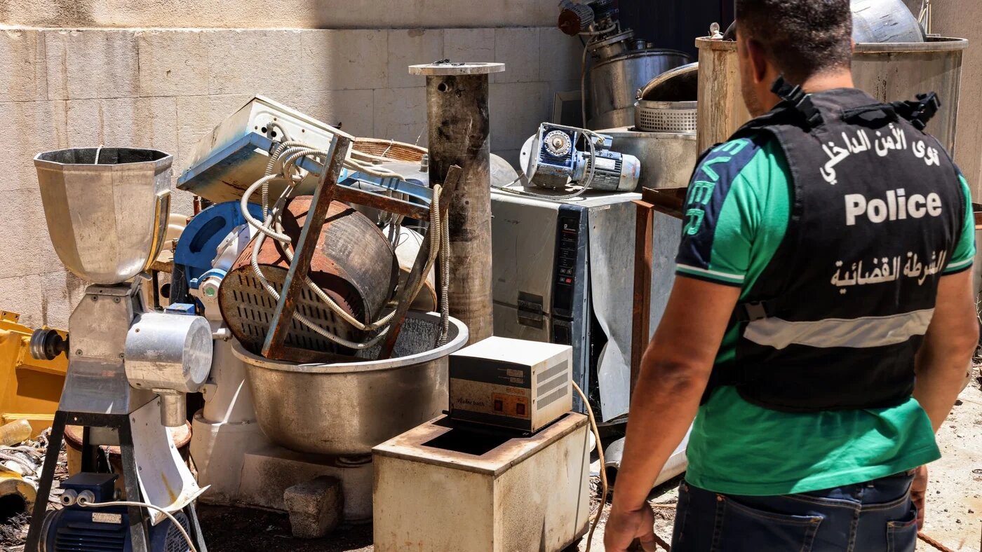 A Lebanese judicial police official inspects confiscated instruments for captagon pill manufacturing at the judicial police headquarters in the city of Zahle in Lebanon's central Bekaa valley on July 21, 2022 (AFP)