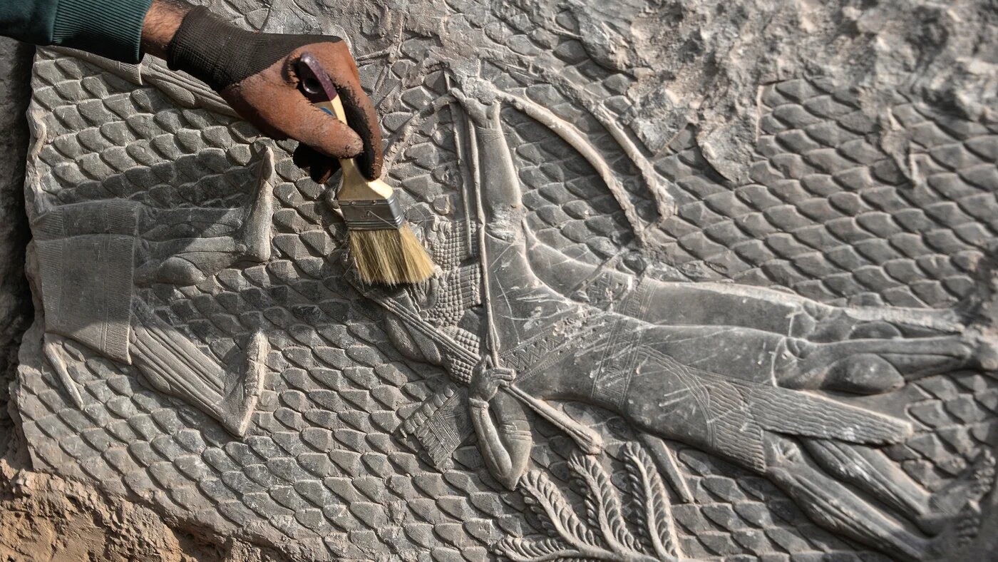 An Iraqi worker excavates a rock-carving relief recently found at the Mashki Gate, one of the monumental gates to the ancient Assyrian city of Nineveh, on the outskirts of what is today the northern Iraqi city of Mosul on October 19, 2022. Zaid AL-OBEIDI / AFP