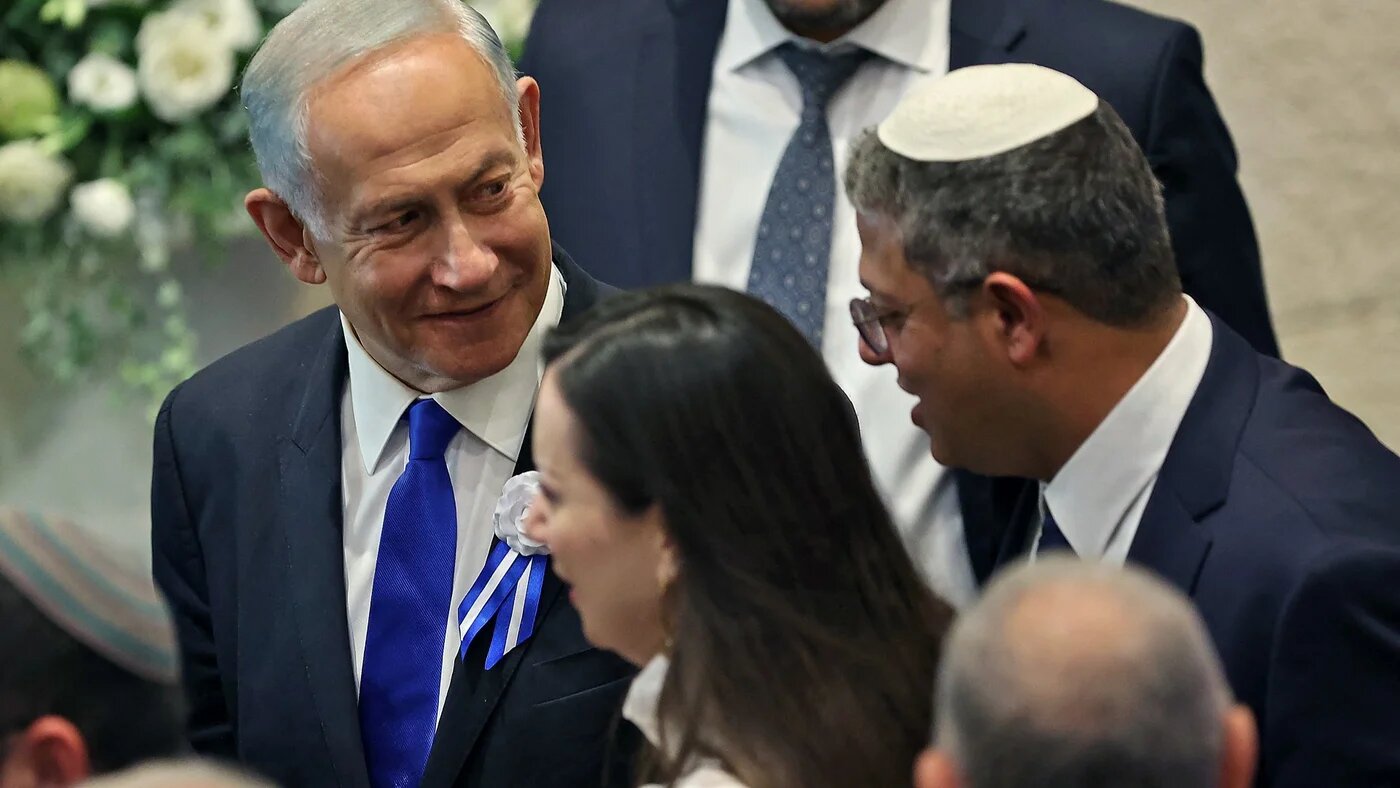 Itamar Ben-Gvir (R) chats with incoming Prime Minister Benjamin Netanyahu (L) during the swearing in ceremony of the new Israeli parliament in Jerusalem, on 15 November (AFP)