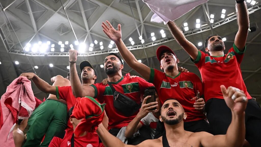 Les supporters marocains célèbrent la victoire avec leurs joueurs, au stade Al-Thumama de Doha, le 10 décembre 2022 (AFP/Kirill Kudryavtsev)