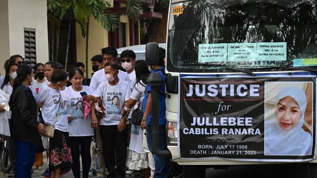 Relatives of Jullebee Ranara, a domestic helper who was killed in Kuwait, grieve during her funeral at a cemetery in Las Pinas, Metro Manila on February 5, 2023 (AFP)