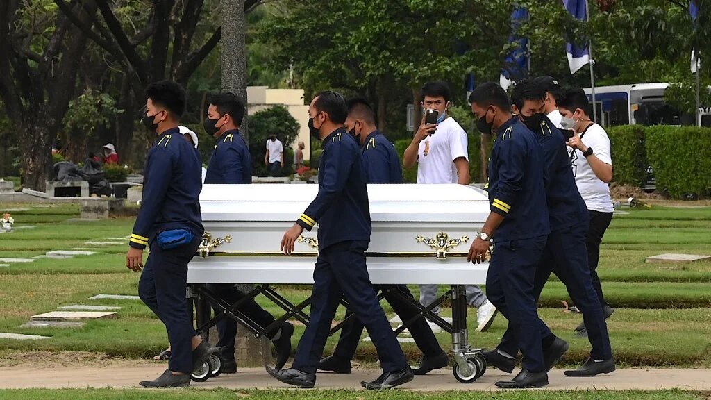 Men carry the coffin of Jullebee Ranara and grieve during her funeral at a cemetery in Las Pinas, Metro Manila on 5 February 2023 (AFP)