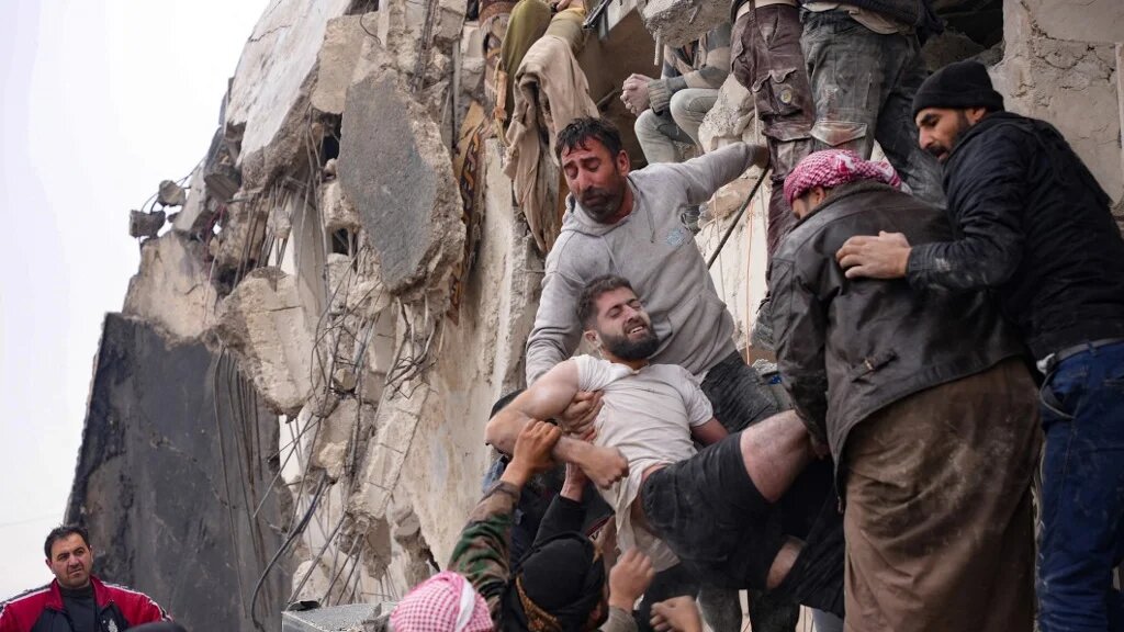 Des habitants récupèrent un homme blessé dans les décombres d’un immeuble à Jindires, dans la campagne de la ville d’Afrin, dans le nord-ouest de la Syrie, le 6 février 2023 (AFP/Rami al-Sayed)