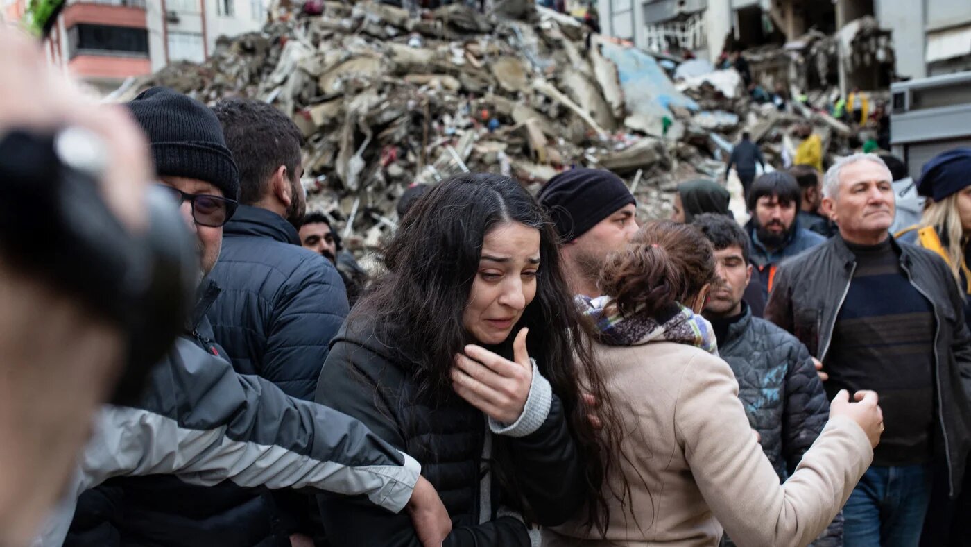 A woman reacts as rescuers search for survivors through the rubble of collapsed buildings in Adana, on February 6, 2023 after a 7,8 magnitude earthquake struck the country's south-east (AFP)