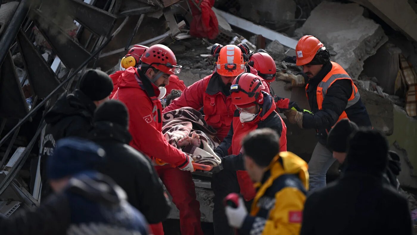 Rescue personnel carry a rescued young man on a strecher through the rubble of buildings in kahramanmaras, the quake's epicentre, after a 7.8-magnitude earthquake struck the country's southeast on 7 February, 2023. (AFP)