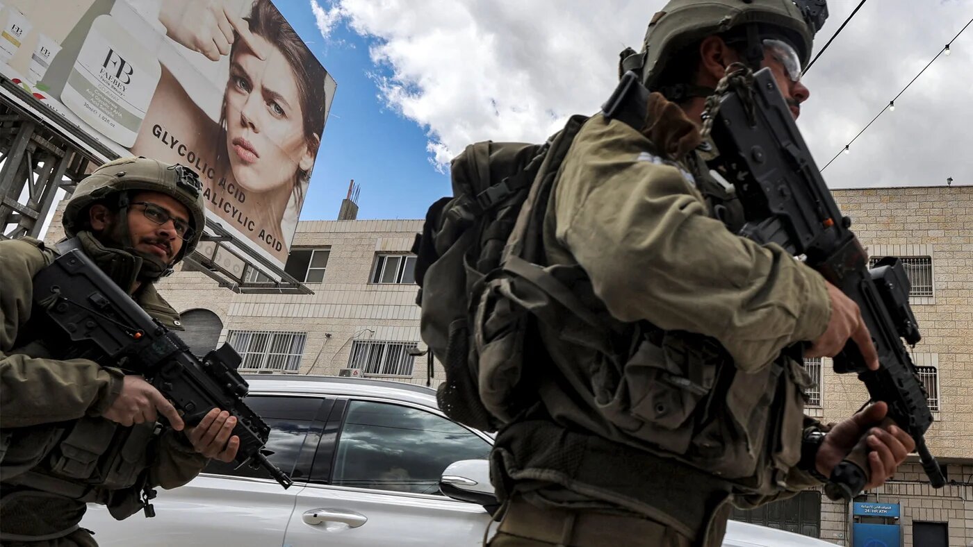 Israeli soldiers stand before Palestinian protesters (not pictured) gathering for a Land Day demonstration in the Palestinian town of Huwara in the occupied West Bank on March 31, 2023 (AFP)