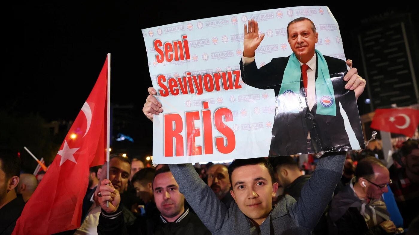 A supporter of Turkish President Tayyip Erdogan holds a poster which reads "We Love You Chief" outside the AKP headquarters after polls closed in Turkey's presidental and parliamentary elections in Ankara, Turkey May 15, 2023. Turkey is braced for its first election runoff after a night of high drama showed President Recep Tayyip Erdogan edging ahead of his rival but failing to secure a first-round win (AFP)