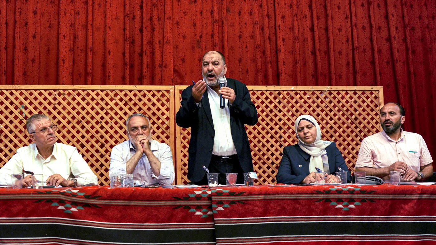 Tayseer Abu Sneineh, (centre), Mayor of the Palestinian city of Hebron, discusses locals' water shortage problems during a session at the city's municipality hall in the occupied West Bank on 24 August 2023 (AFP/Hazem Bader H)
