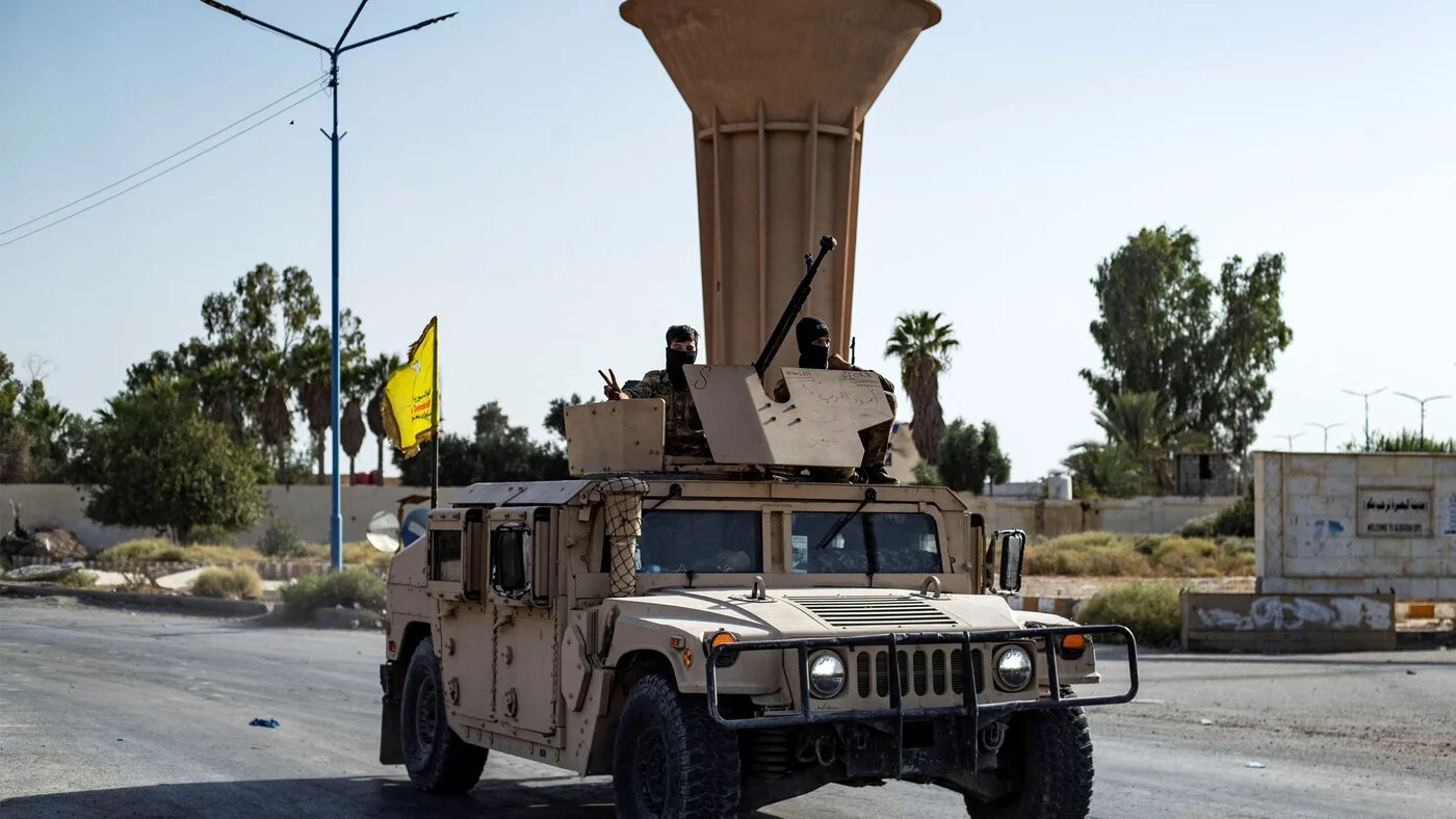 A Syrian Democratic Forces (SDF) vehicle on the road as fighters impose a curfew in the town of al-Busayrah in Deir Ezzor