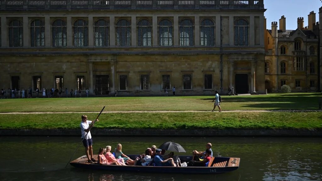 People punt past the Wren Library, part of Trinity College, on the River Cam in Cambridge, England, on 9 September 2023 (Justin Tallis/AFP)