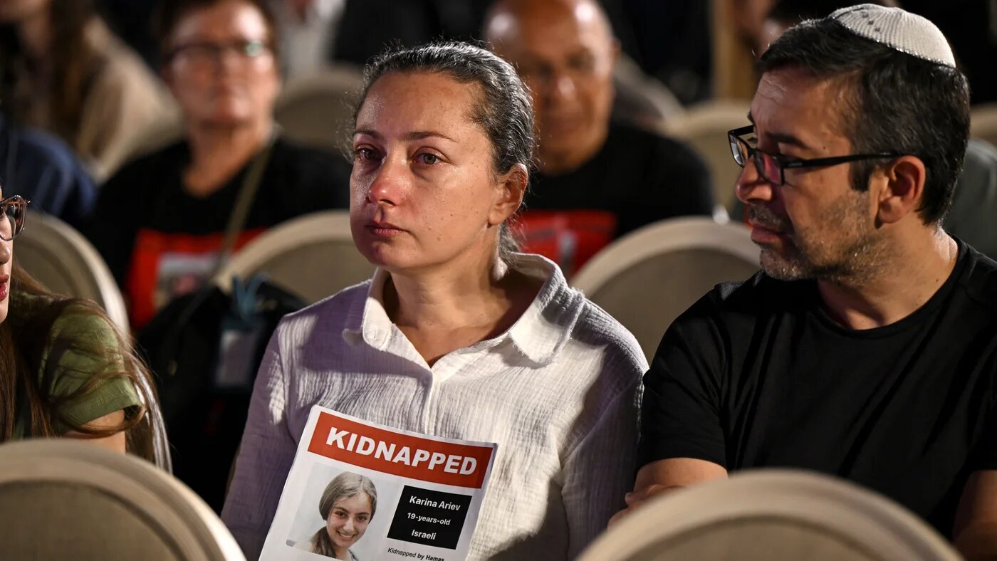 People hold a poster of hostage Karina Ariev as they gather at a spot overlooking the Western Wall Plaza in Jerusalem as they attend the Global Day of Unity and Prayer with Israel’s Hostages and Missing Families Forum (AFP)
