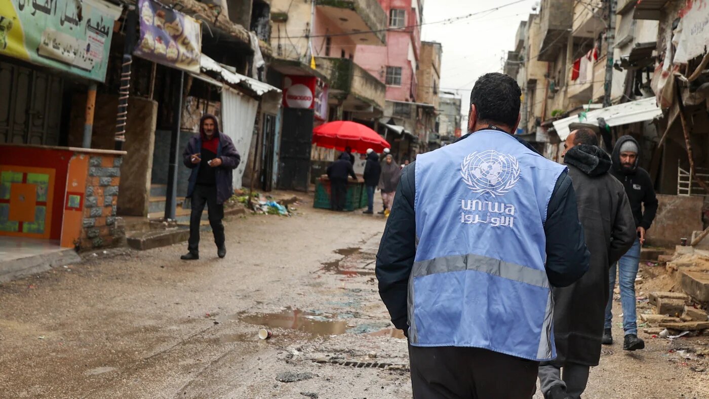 Un employé de l’UNRWA marche dans une rue dévastée par le passage de véhicules militaires israéliens et de bulldozers, dans le camp de Balata en Cisjordanie occupée, le 4 février 2024 (AFP/Jaafar Ashtiyeh)