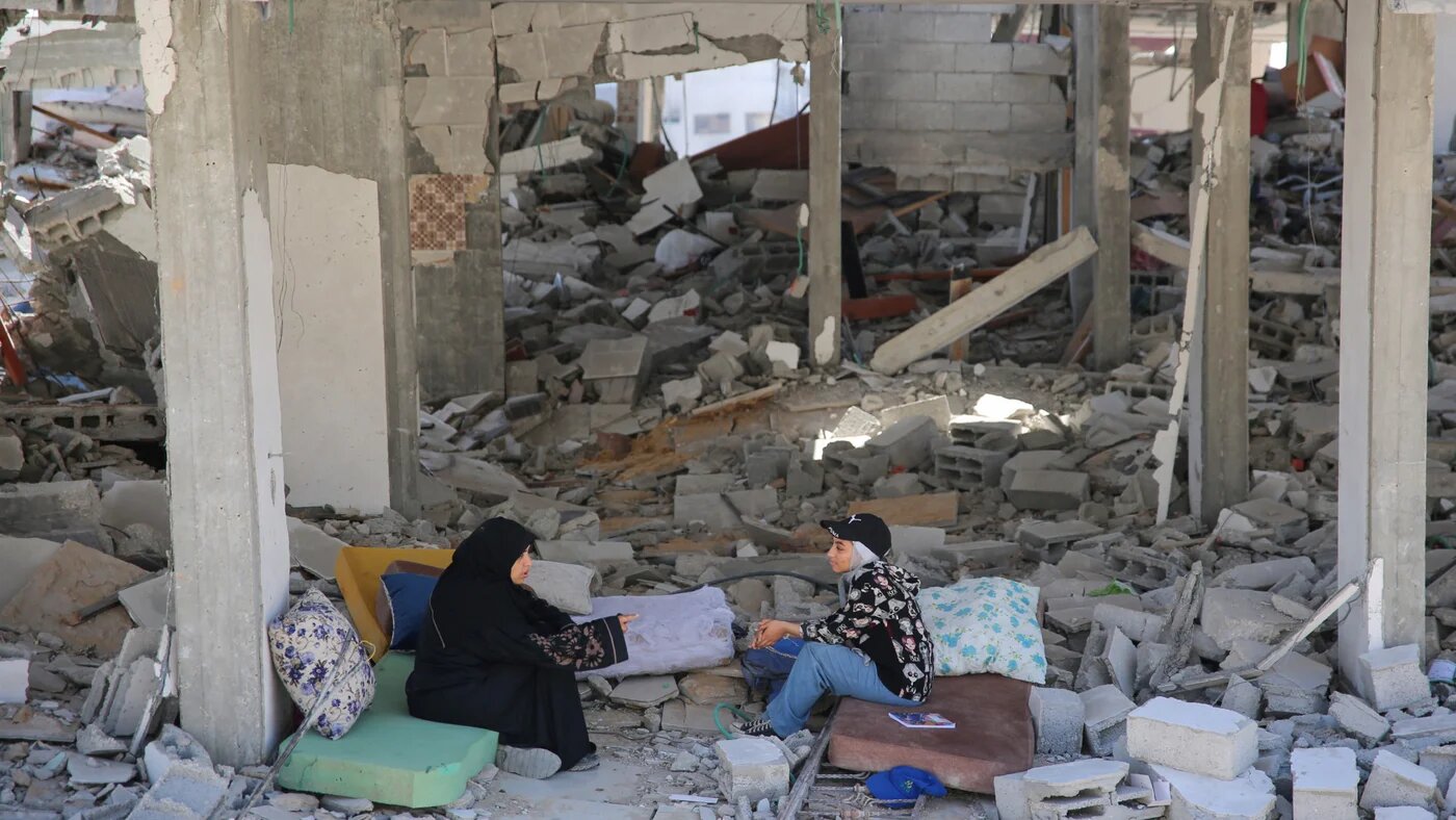 Palestinian women sit on rubble at al-Shifa Hospital in Gaza City on 3 April 2024 after Israeli forces withdrew from the site (AFP)