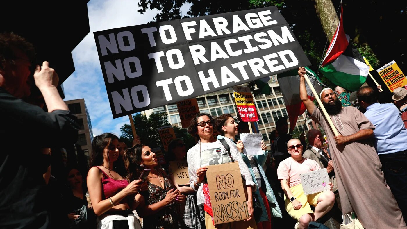 People hold anti-racism placards as they take part in a "Stop the Far Right" demonstration on a national day of protest outside the headquarters of the right-wing Reform UK political party in London on 10 August (Benjamin Cremel/AFP)