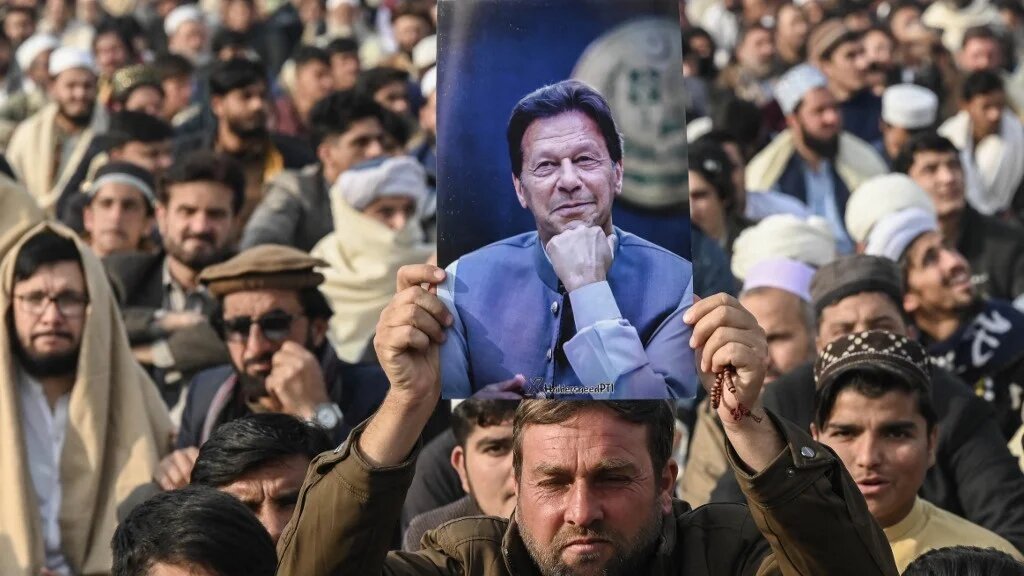 A supporter of Imran Khan holds his poster at a Pakistan Tehreek-e-Insaf (PTI) gathering on Martyrs’ Day to honour those said to have died during a protest in Peshawar on 15 December 2024 (AFP)