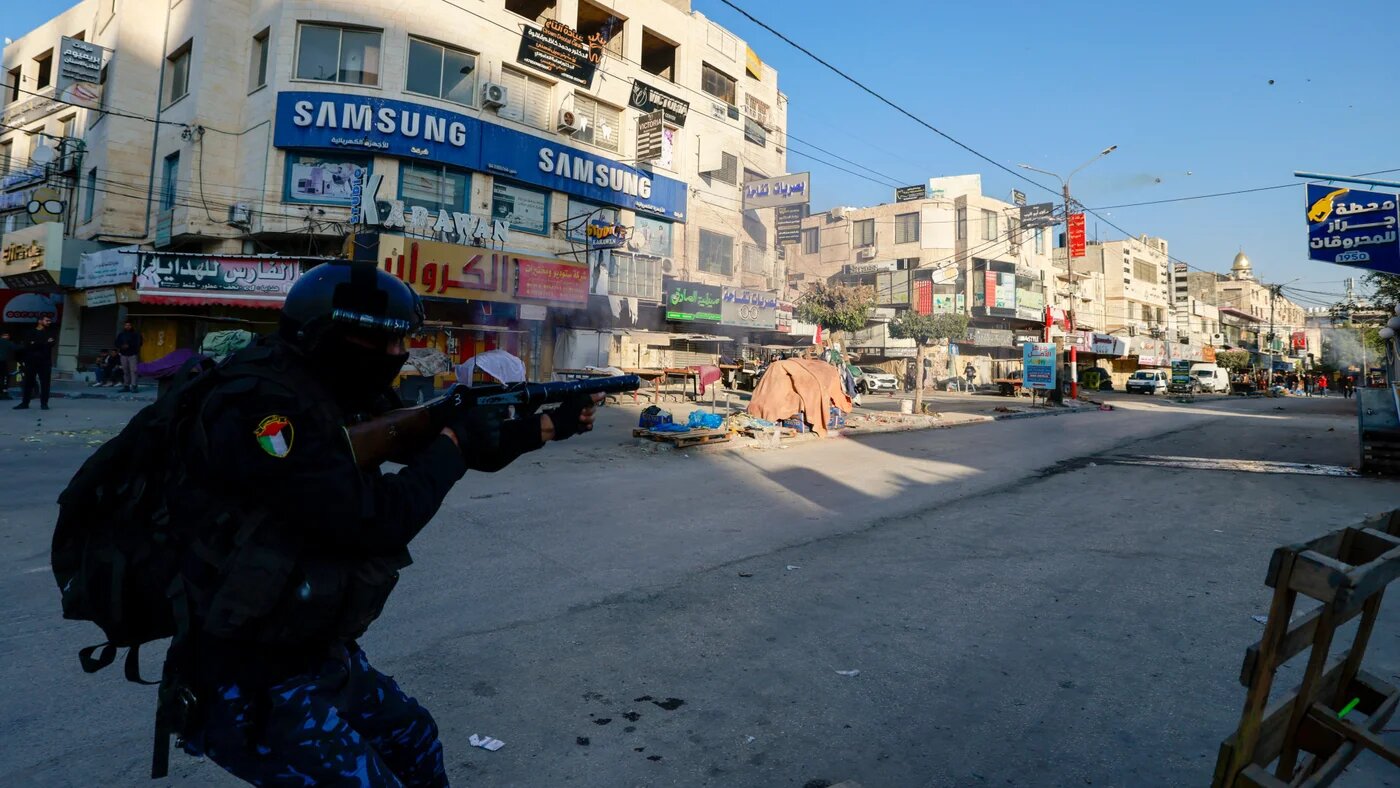 A member of the Palestinian Authority security forces fires tear gas towards a protest against their security operation in Jenin in the occupied West Bank on 16 December 2024 (Jaafar Ashtiyeh/AFP)