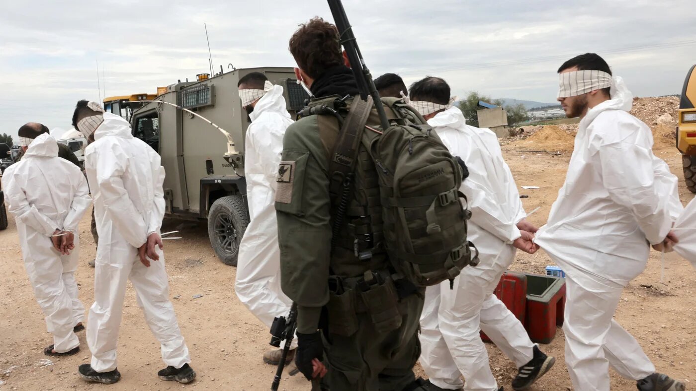 An Israeli soldier supervises the transfer of Palestinian men arrested during a military raid on Jenin on the border with the occupied West Bank, on 22 January 2025 (Gil Cohen-Magen/AFP)